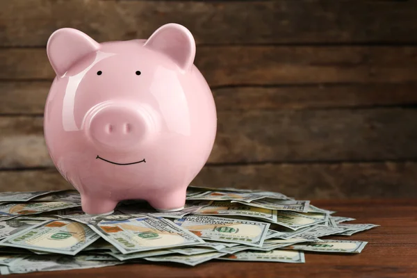 Caja de dinero de cerdo y billetes en dólares —  Fotos de Stock