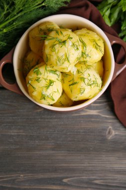 Masada bir kapta yeşillikleri ile haşlanmış patates yakın çekim