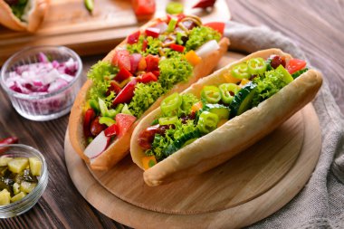 Sosisli sandviç ve sebze ahşap kesme tahtası üzerinde