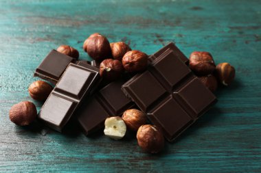 Fındık rengi ahşap arka plan üzerinde siyah çikolata parçaları