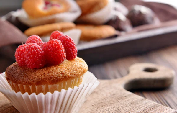 Läckra muffins med bär och färsk mynta på träbord nära håll — Stockfoto