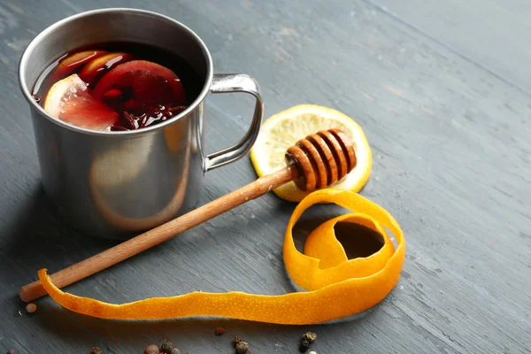 Vino rimuginato in una tazza con agrumi su fondo grigio in legno, primo piano — Foto Stock