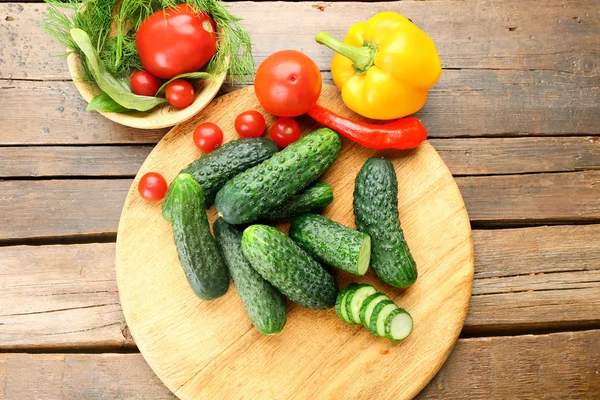 Složení, okurky, rajčata a papriky kruhů na dřevěné pozadí — Stock fotografie