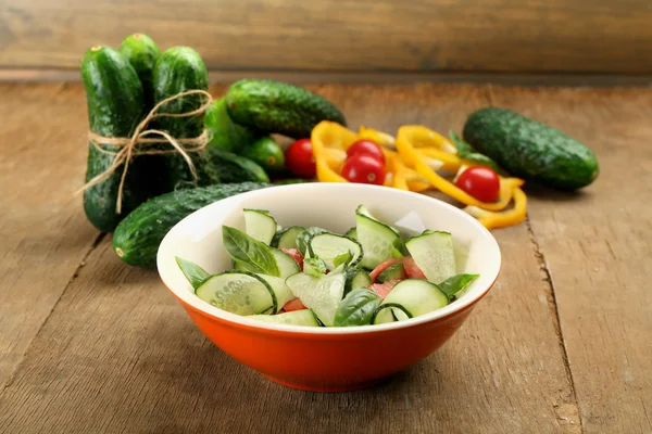 Salada de legumes com pepinos em fundo de madeira — Fotografia de Stock