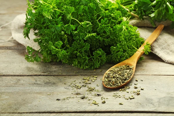 Fresh and dries parsley on wooden background — Stock Photo, Image
