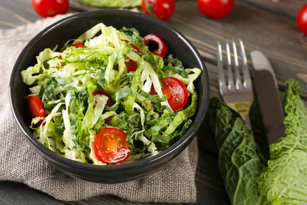 Salada de repolho e tomate Savoy servida em tigela na mesa de madeira — Fotografia de Stock