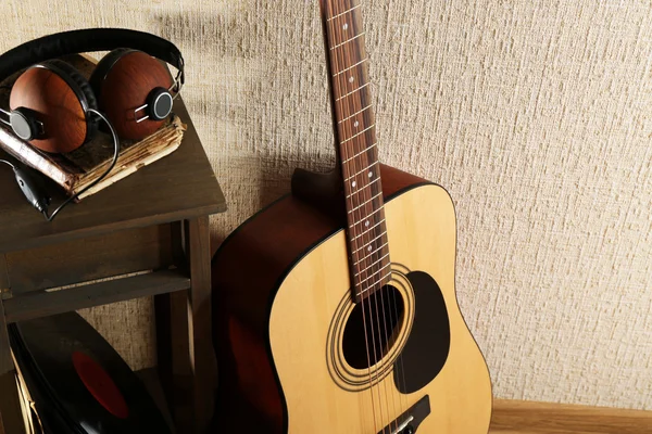 Acoustic guitar against wall — Stock Photo, Image