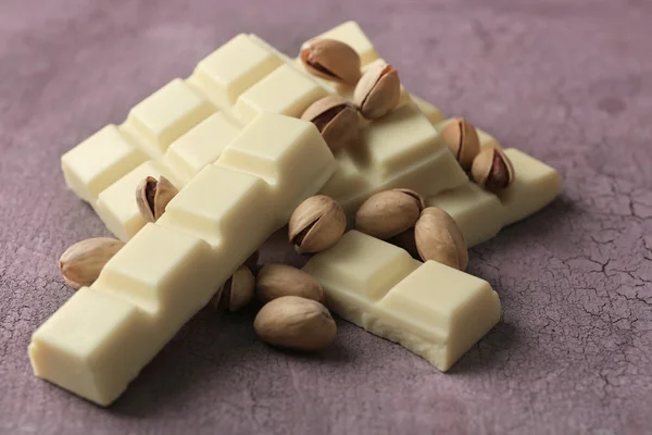 Piezas de chocolate blanco con nueces sobre fondo de madera de color —  Fotos de Stock