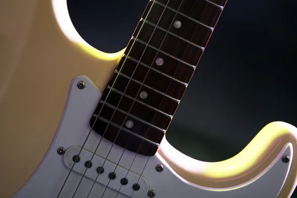 Parte da guitarra elétrica, sobre fundo iluminado escuro — Fotografia de Stock