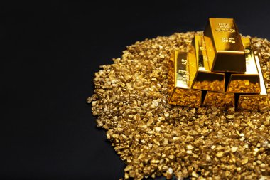 Altın külçeleri ve gri arka plan üzerinde nugget taneleri