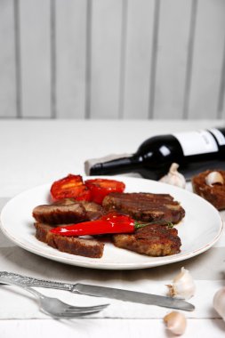 Kavrulmuş sığır filetosu ve ahşap arka plan üzerinde plaka üzerinde ızgara sebze