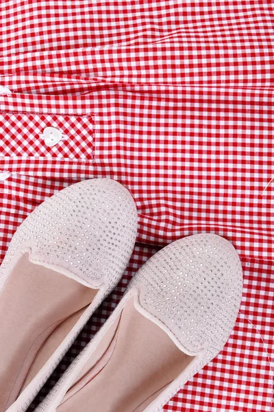 Glanzende roze schoenen op rode plaid shirt achtergrond, close-up — Stockfoto