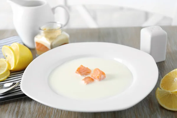 Deliciosa sopa de crema de salmón en plato blanco sobre mesa de madera, de cerca — Foto de Stock