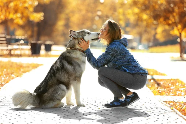 Kvinna promenader med hund i parken — Stockfoto