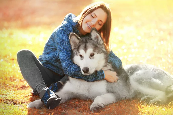 Vrouw zitten met haar hond in park — Stockfoto