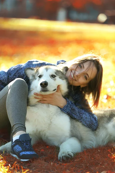 Kobieta siedząca z psem w parku — Zdjęcie stockowe