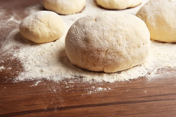 Bolas de masa para pizza sobre tabla de madera enharinada —  Fotos de Stock