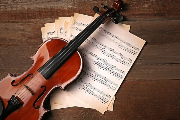 Violin and music papers on wooden background — Stock Photo, Image