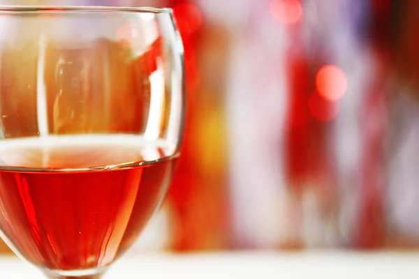 A glass of pink wine on blurred lighted background — Stock Photo, Image