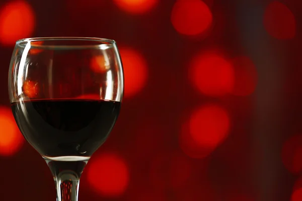 Ein Glas Rotwein auf unscharf beleuchtetem Hintergrund — Stockfoto