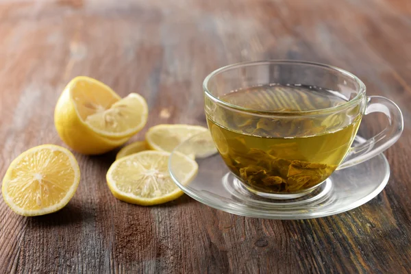 Glas Tee und in Scheiben geschnittene Zitrone auf Holzgrund — Stockfoto