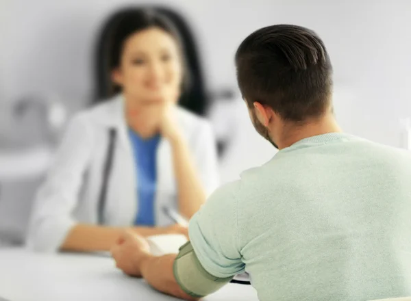 Doctora examinando la presión arterial del paciente — Foto de Stock