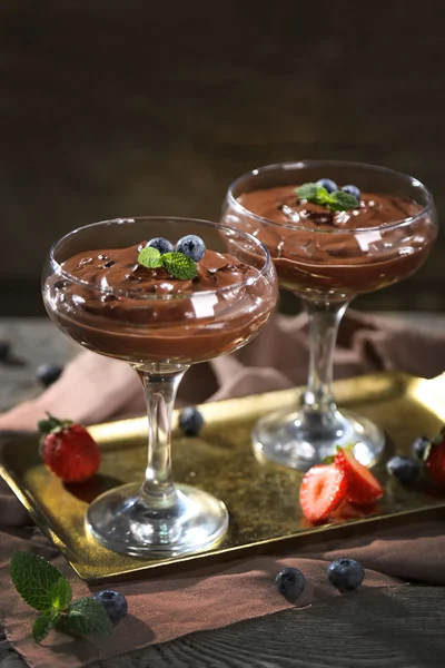 Postre de chocolate en vasos y bayas frescas sobre fondo de madera de color —  Fotos de Stock