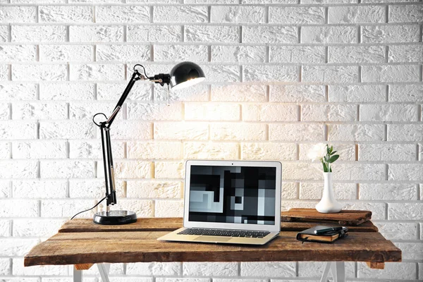 Modern lamp and laptop on table — Stock Photo, Image