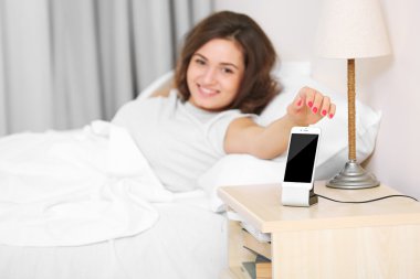 Güzel ve genç birbayan mobil çalar saat ile uyanma