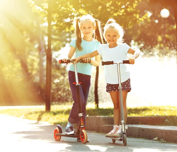 Kleine Mädchen fahren auf Rollern — Stockfoto