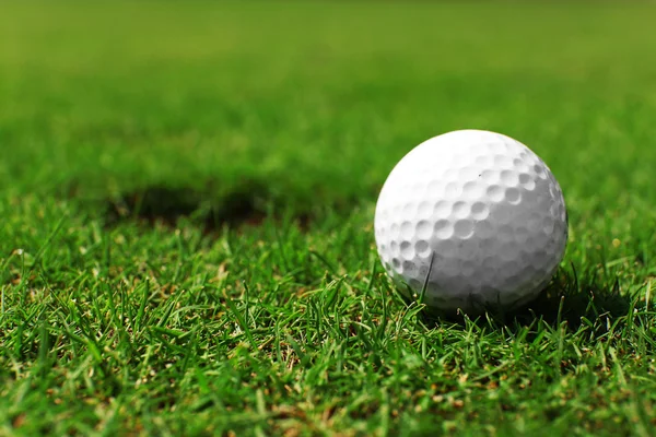 Pelota de golf en el labio de la taza —  Fotos de Stock