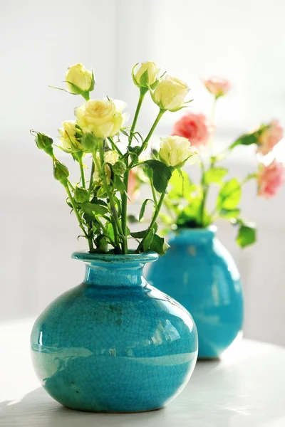 Schöne Rosen in türkisfarbenen Vasen auf Fensterhintergrund — Stockfoto