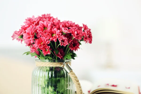Hermosas flores en jarrón en la mesa en la habitación — Foto de Stock
