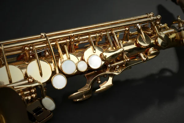 Beautiful golden saxophone on black background, close up — Stock Photo, Image