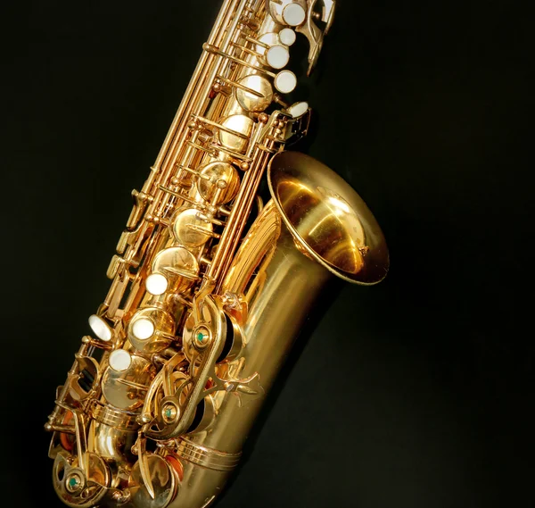 Hermoso saxofón dorado sobre fondo negro, de cerca — Foto de Stock