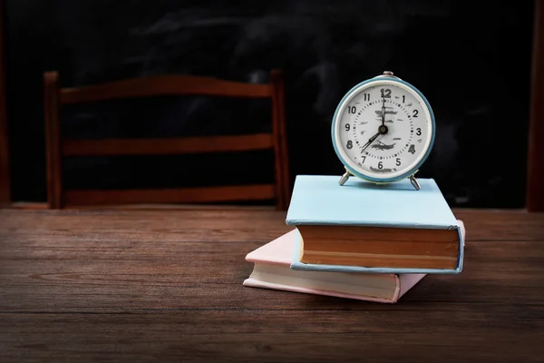 Libros y reloj en la mesa —  Fotos de Stock