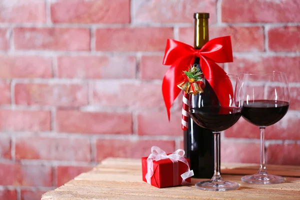 Flaska rött vin och glas med julklappar — Stockfoto