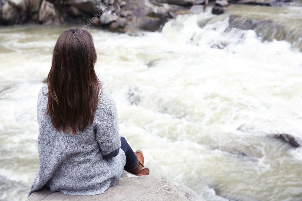 Photography of woman near beautiful waterfall on rocks
