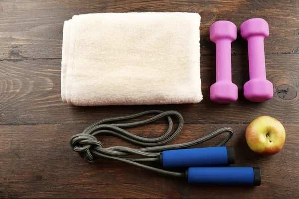 Sportutrustning, handduk och äpple på trä bakgrund — Stockfoto