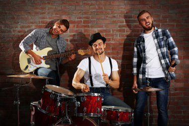Bateri ve gitar çalmaya müzisyenler