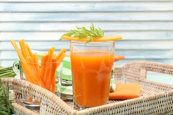 El vaso del jugo de zanahoria con los trozos de hortalizas a la mesa se acercan —  Fotos de Stock