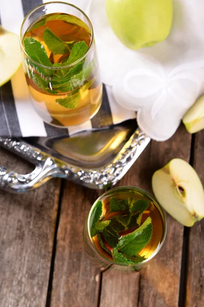 Glazen appelsap met fruit en verse munt op tafel close-up — Stockfoto