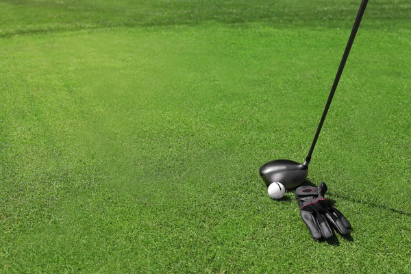 Clubes de golfe com bola e luva preta — Fotografia de Stock