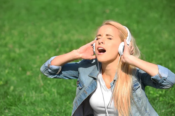 Vrouw met oortelefoons en smartphone — Stockfoto