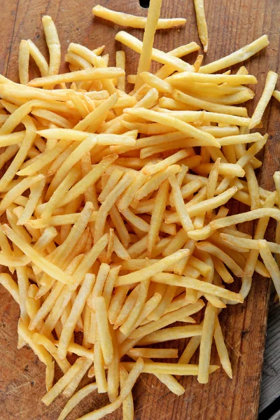 Batatas fritas francesas na tábua de corte — Fotografia de Stock