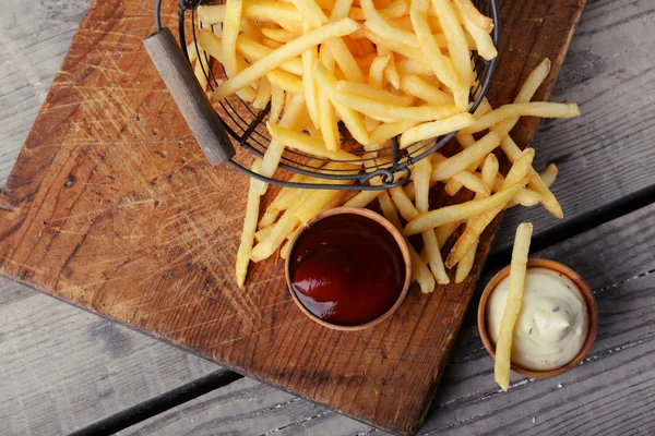Fransızca patates ahşap arka plan üzerinde metal sepette kızarmış — Stok fotoğraf