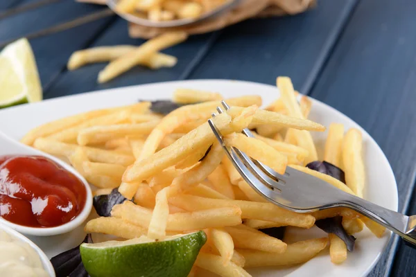 Batatas fritas francesas com molho e limão na bandeja branca — Fotografia de Stock