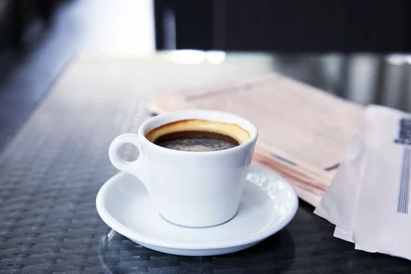 Taza de sabroso café y periódicos en la cafetería — Foto de Stock