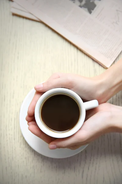 Taza de café con manos y periódico — Foto de Stock