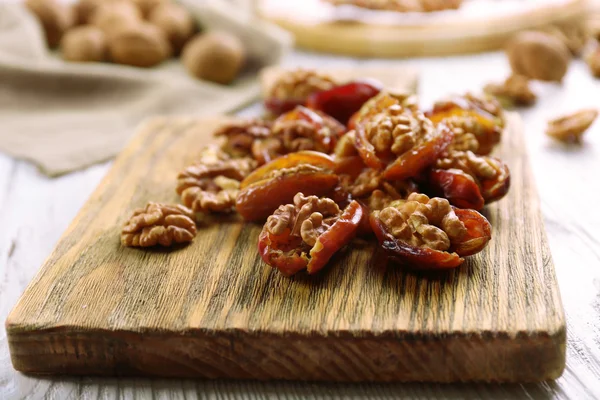Walnut in date fruit on cutting board, close-up — Stock Photo, Image